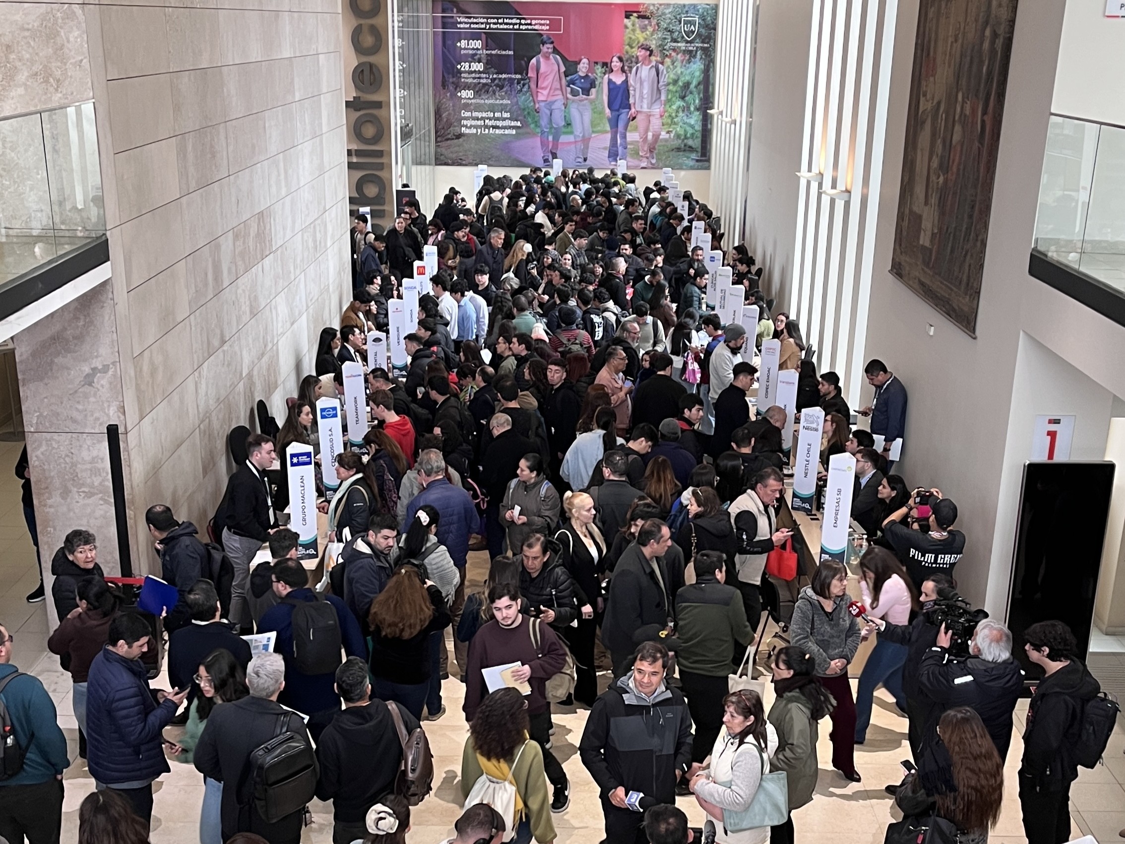 Imagen de portada de la Feria Punto Empleo en la Universidad Autónoma de Chile. La imagen, a través de un plano en picado, muestra a una gran cantidad de personas recorriendo diferentes puestos de trabajo en la zona principal de la Universidad Autónoma.
