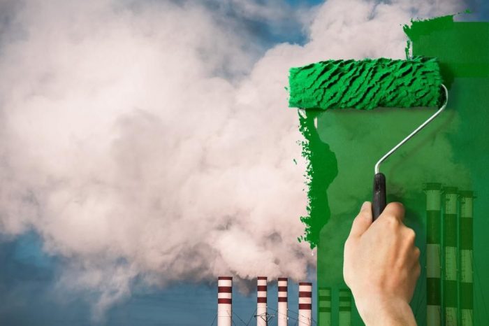 Portada de columna Greenwashing que muestra una gran fábrica soltando humos al aire, en primer plano hay una mano con un rodillo de pintura verde pintando sobre la imagen de la fábrica, simbolizando como el greewashing solo tapa el funcionamiento nocivo de los elementos contaminantes del mundo.